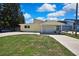 Charming single-story home with a covered carport and well-maintained front lawn on a sunny day at 7308 Maryland Ave, Hudson, FL 34667