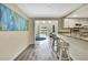 Bright kitchen with stainless steel appliances and bar seating opens to cozy living area at 7308 Maryland Ave, Hudson, FL 34667