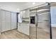 Spacious kitchen with a stainless steel refrigerator and ample storage in white cabinets and pantry at 7308 Maryland Ave, Hudson, FL 34667