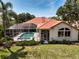 Aerial view of home featuring a large screened-in pool, landscaped yard, and a vibrant orange tile roof at 766 Shadow Bay Way, Osprey, FL 34229