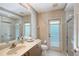 Well-lit bathroom featuring a large mirror, glass shower, and a door to the exterior at 766 Shadow Bay Way, Osprey, FL 34229