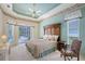 Bedroom featuring tray ceilings, a window, and sliding doors to an outdoor pool at 766 Shadow Bay Way, Osprey, FL 34229