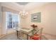 Elegant dining room with a chandelier, glass table, and neutral decor, perfect for formal gatherings at 766 Shadow Bay Way, Osprey, FL 34229