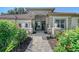 Inviting walkway leading to a charming home exterior, enhanced by lush landscaping with vibrant flowers at 766 Shadow Bay Way, Osprey, FL 34229