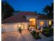 Charming home with a brick driveway, lush landscaping, red front door, and ample outdoor lighting at 766 Shadow Bay Way, Osprey, FL 34229