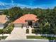 Home showcasing beautiful landscaping, a brick driveway, and a prominent red-tiled roof under a bright sky at 766 Shadow Bay Way, Osprey, FL 34229