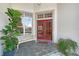 Welcoming front porch with red double doors, a bench, and potted plants, creating a cozy entry at 766 Shadow Bay Way, Osprey, FL 34229