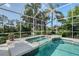Screened-in pool area showcasing a relaxing spa and beautiful landscaping at 766 Shadow Bay Way, Osprey, FL 34229