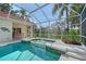 Inviting pool and spa surrounded by a screened enclosure and lush landscaping at 766 Shadow Bay Way, Osprey, FL 34229