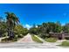 Inviting street view of Woodlands community with lush trees, landscape, and clear blue sky at 766 Shadow Bay Way, Osprey, FL 34229