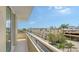 Open balcony view showcasing the neighborhood with well-maintained buildings, lush greenery, and clear blue skies at 800 N Tamiami Trl # 317, Sarasota, FL 34236