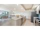 Open-concept kitchen with modern stainless steel appliances, a stylish island with seating, and a view of the living area at 800 N Tamiami Trl # 317, Sarasota, FL 34236
