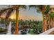 Picturesque sunrise view of a manicured landscape with palm trees, a tranquil waterway, and a fountain at 800 N Tamiami Trl # 317, Sarasota, FL 34236