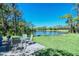 Scenic backyard with a lake view, patio furniture, and lush greenery at 8735 Olde Hickory Ave # 8205, Sarasota, FL 34238