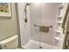 Bathroom shower with white tiled walls, glass door, and grab bar for safety at 8735 Olde Hickory Ave # 8205, Sarasota, FL 34238