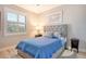 Bedroom with a blue quilted bed, side tables, and shutters covering the window at 8735 Olde Hickory Ave # 8205, Sarasota, FL 34238
