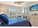 Bedroom featuring blue quilted bedding, natural light, and balcony access with scenic views at 8735 Olde Hickory Ave # 8205, Sarasota, FL 34238