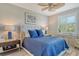 Comfortable bedroom with blue bedding, stylish furniture, ceiling fan, and bright natural light at 8735 Olde Hickory Ave # 8205, Sarasota, FL 34238