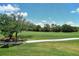 Scenic view of the golf course with lush green grass and mature trees, seen through a screen at 8735 Olde Hickory Ave # 8205, Sarasota, FL 34238