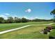 Lush green golf course with a winding path, viewed through a screened-in lanai for relaxed outdoor enjoyment at 8735 Olde Hickory Ave # 8205, Sarasota, FL 34238