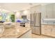 Well lit kitchen featuring stainless steel appliances, island with granite counters, and tile backsplash at 8735 Olde Hickory Ave # 8205, Sarasota, FL 34238