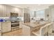 Bright kitchen with granite counters, stainless steel appliances, white cabinets, and island with seating at 8735 Olde Hickory Ave # 8205, Sarasota, FL 34238