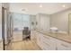 Kitchen with white cabinets, granite counters, stainless steel refrigerator, and adjacent desk area at 8735 Olde Hickory Ave # 8205, Sarasota, FL 34238