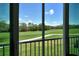 Scenic view of a lush, green golf course from a screened lanai, offering a tranquil outdoor space at 8735 Olde Hickory Ave # 8205, Sarasota, FL 34238
