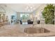 View from kitchen to living room with modern lighting, comfortable seating, and balcony access at 8735 Olde Hickory Ave # 8205, Sarasota, FL 34238
