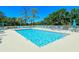 Community pool featuring chairs, trees and clear blue skies at 8735 Olde Hickory Ave # 8205, Sarasota, FL 34238