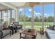 Bright sunroom featuring wicker furniture and floor-to-ceiling windows with a view of the golf course at 8735 Olde Hickory Ave # 8205, Sarasota, FL 34238