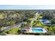 Picturesque aerial view of a pool, tennis courts, and community amidst lush green landscaping at 8755 Olde Hickory Ave # 7105, Sarasota, FL 34238