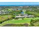 Expansive aerial view showcasing condo buildings situated near a golf course, lakes, and scenic landscape at 8755 Olde Hickory Ave # 7105, Sarasota, FL 34238