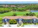 Beautiful aerial view of building with a golf course, landscaping, and lake in the backdrop at 8755 Olde Hickory Ave # 7105, Sarasota, FL 34238