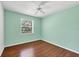 Bedroom with neutral walls, wood floors, ceiling fan, and a bright window at 8755 Olde Hickory Ave # 7105, Sarasota, FL 34238