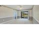 Bright bedroom featuring neutral carpet, sliding glass doors to lanai, and gray accent wall at 8755 Olde Hickory Ave # 7105, Sarasota, FL 34238