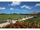Golf driving range with manicured green, hitting mats and colorful tropical landscaping, offering a serene practice area at 8755 Olde Hickory Ave # 7105, Sarasota, FL 34238