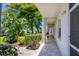 Exterior showcases lush landscaping and a tiled walkway leading to the condo entrance at 8755 Olde Hickory Ave # 7105, Sarasota, FL 34238