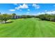 Scenic view of lush green golf course with blue skies and tropical foliage near the apartments at 8755 Olde Hickory Ave # 7105, Sarasota, FL 34238