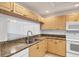 Close-up of the kitchen sink and countertop area with light wood cabinets and granite countertops at 8755 Olde Hickory Ave # 7105, Sarasota, FL 34238