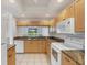 Kitchen featuring white appliances, light wood cabinets, and a window overlooking the yard at 8755 Olde Hickory Ave # 7105, Sarasota, FL 34238