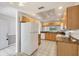 Bright kitchen with light wood cabinets, granite countertops, and white appliances at 8755 Olde Hickory Ave # 7105, Sarasota, FL 34238
