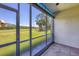 Enclosed lanai showing the golf course and butterfly sticker on the glass door at 8755 Olde Hickory Ave # 7105, Sarasota, FL 34238