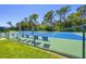 Inviting tennis court area with shade umbrellas and seating for a relaxing game at 8755 Olde Hickory Ave # 7105, Sarasota, FL 34238
