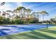 Tennis court featuring an immaculate playing surface with trees, landscaping, and a net at 8755 Olde Hickory Ave # 7105, Sarasota, FL 34238
