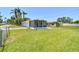 Large backyard with lush grass and chain link fencing provides ample space for outdoor activities at 1200 25Th W Ave, Palmetto, FL 34221