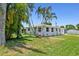 Charming single-story home featuring a well-maintained lawn, beautiful palm trees, and a welcoming facade at 1200 25Th W Ave, Palmetto, FL 34221