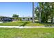 Charming home showcasing a well-maintained lawn and tropical palm trees, with a car parked on the side driveway at 1200 25Th W Ave, Palmetto, FL 34221