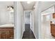 A hallway featuring dark wood floors, a linen closet, and adjacent to the kitchen and bathroom at 1200 25Th W Ave, Palmetto, FL 34221