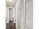 A hallway featuring dark wood floors, a linen closet, and white trim and paint at 1200 25Th W Ave, Palmetto, FL 34221